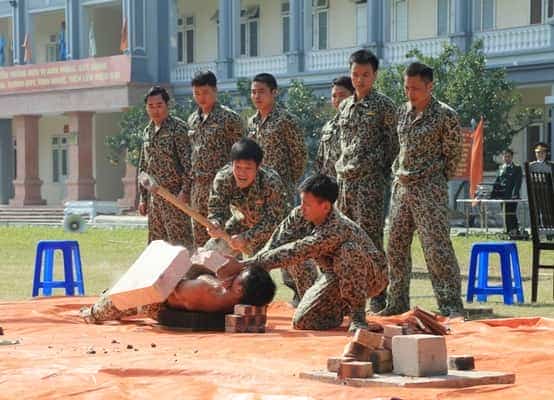 <span style="color: black;"><em><span style="color: black;"><em><span style="color: black;">Dùng búa tạ công phá tảng đá nặng gần 100kg kê trên bụng, lưng nằm trên bàn chông.</span>